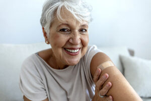 happy senior lady with bandaid on arm
