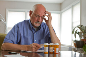 A man goes over his list of medications to see if he takes any that may cause senior falls.