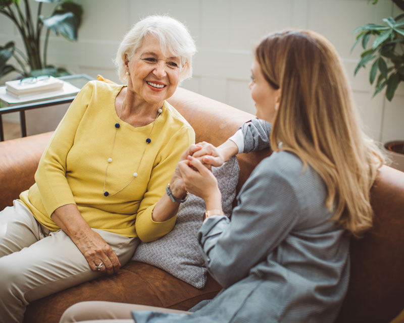 Caregiver and client talking on couch